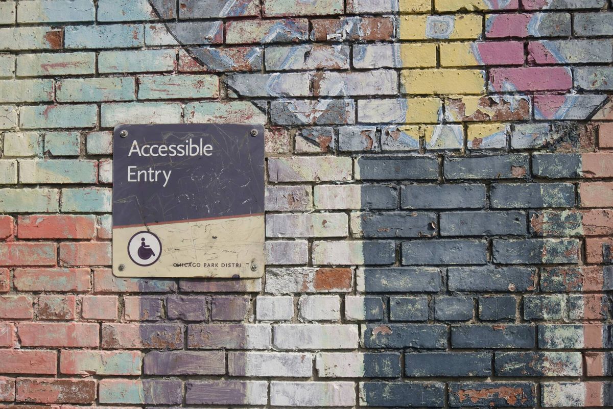 Sign for Accessible Entry on painted brick wall